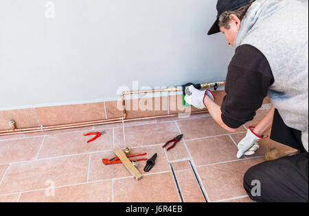 Système d'irrigation goutte à goutte. Un jardinier sont définition d'une minuterie d'arrosage électronique sur une terrasse. L'irrigation goutte à goutte micro cuivre luxueux pour les plantes en pots Banque D'Images