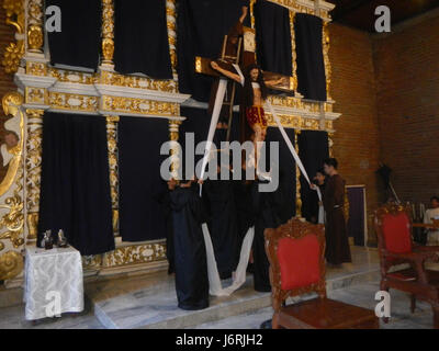 Cette image capture la vénération de la Croix lors des services du vendredi Saint à l’église Santa Monica à Minalin, Pampanga, Philippines, un événement religieux important pour la communauté catholique locale. Banque D'Images