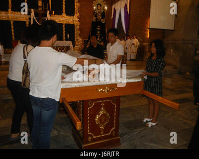 L'image capture la cérémonie de la Croix de vénération du vendredi Saint 2017 à l'église Santa Monica à Minalin, Pampanga. Il représente la tradition religieuse de vénérer la croix pendant la semaine Sainte, pratique observée dans de nombreuses communautés chrétiennes. Banque D'Images