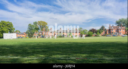 Cricket Village joué sur le green à Hartley Wintney dans le Hampshire, au Royaume-Uni Banque D'Images