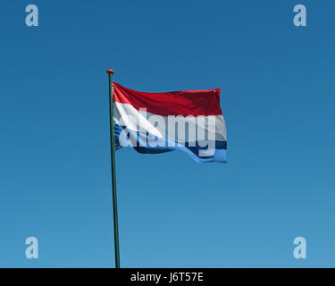 Pavillon des Pays-Bas sur mât de forme dans le vent. Drapeau officiel national des Pays-Bas sur fond de ciel bleu. Symbole patriotique, bannière Banque D'Images