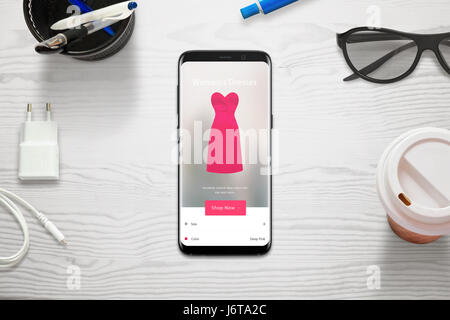 Magasinage en ligne avec un téléphone mobile. Femme Choisissez la taille et la couleur de robe avec l'app store. Vue de dessus de bureau et mobiles. Banque D'Images