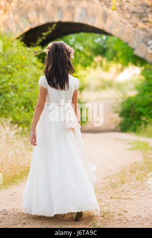 Robe de communion fille en marchant sur un chemin dans le champ Banque D'Images