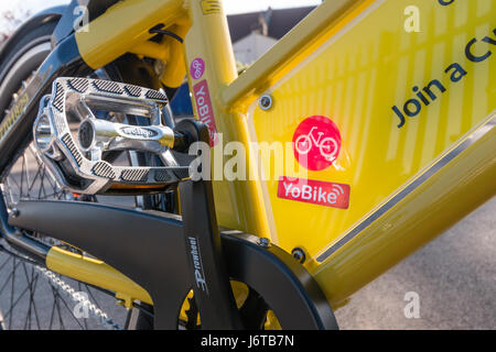 'Un' YoBike : un suivi GPS vélo jaune vif disponibles à la location pour 1 € de l'heure via une application iPhone ou Android. Banque D'Images