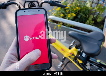 'Un' YoBike : un suivi GPS vélo jaune vif disponibles à la location pour 1 € de l'heure via une application iPhone ou Android. Banque D'Images