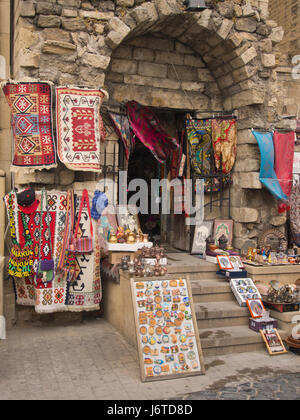 Souvenirs à vendre dans la vieille ville fortifiée de Bakou en Azerbaïdjan, les tapis, les aimants de réfrigérateur, foulards, sacs et plus dans un écran couleur de Banque D'Images