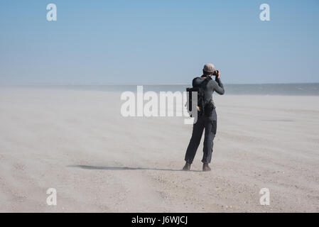 L'homme à prendre des photos au cours de jour de vent sur la plage Banque D'Images