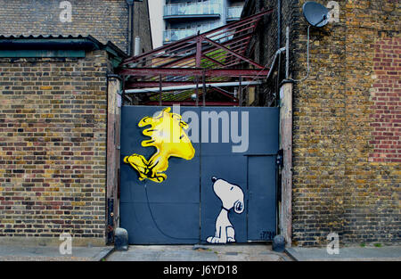 Arachides CARTOON INSPIRÉ LONDON STREET ART, ARTISTE PAR FANAKAPAN. Peinte SUR UNE PORTE DU NORD DE LONDRES AVEC UN BALLON D'HÉLIUM Snoopy et Woodstock. Banque D'Images