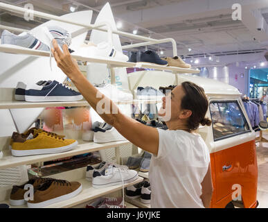 Shopping pour les chaussures. Chaussures Femme regardant une affiche sur VW camper à tirer & Bear magasin de vêtements en Espagne Banque D'Images