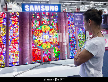 Woman looking at Samsung QLED TV en magasin électrique. Banque D'Images