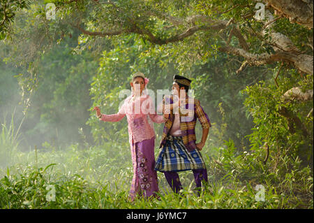 Asian couple portant des tenues traditionnelles de danser dans la forêt, Thaïlande Banque D'Images