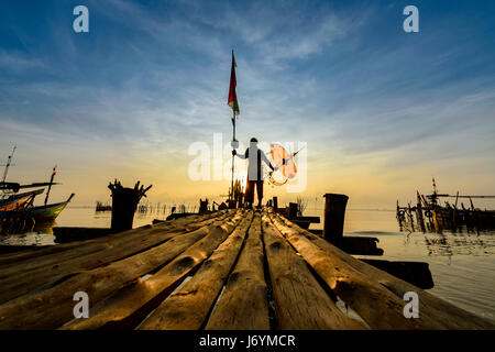 Silhouette d'un fisherman standing on Jetty, Thaïlande Banque D'Images