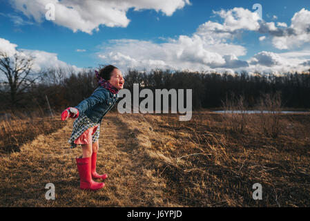 Girl with arms outstretched crier dans le vent