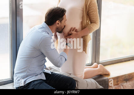 Close up of man kissing wifes pregnant belly Banque D'Images