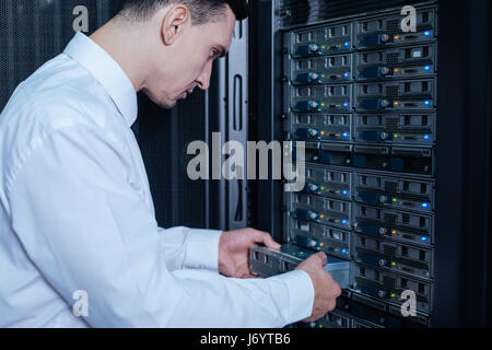 Technicien professionnel sérieux tenant un serveur lame Banque D'Images