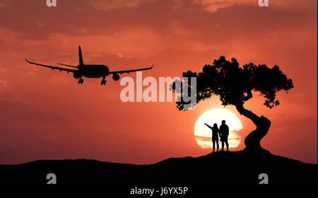 Les gens sous l'arbre de travers et d'avion sur le fond de ciel orange avec soleil. Silhouette d'un couple sur la colline, d'un arbre, d'un aéronef de passagers et Banque D'Images