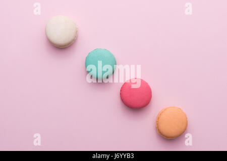 Gâteau macaron pastel colorés sur fond rose macaron ou d'en haut Banque D'Images