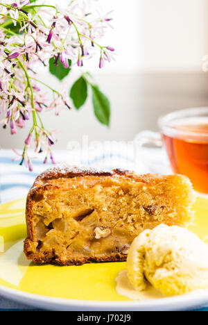 Tranche de gâteau pommes maison douce servi avec de la crème glacée et tasse de thé Banque D'Images