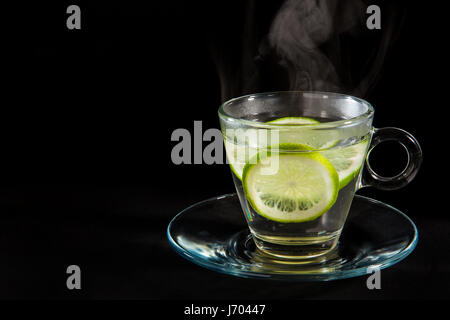 La vapeur chaude de l'eau citronnée isolé sur fond noir Banque D'Images