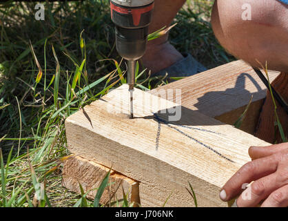 Carpenter en utilisant la mèche et la vis sur le bois à l'extérieur du site de construction Banque D'Images