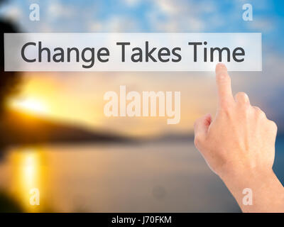 Le changement nécessite du temps - part en appuyant sur un bouton sur l'arrière-plan flou concept . Le commerce, la technologie, internet concept. Stock Photo Banque D'Images