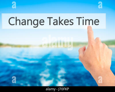 Le changement nécessite du temps - part en appuyant sur un bouton sur l'arrière-plan flou concept . Le commerce, la technologie, internet concept. Stock Photo Banque D'Images