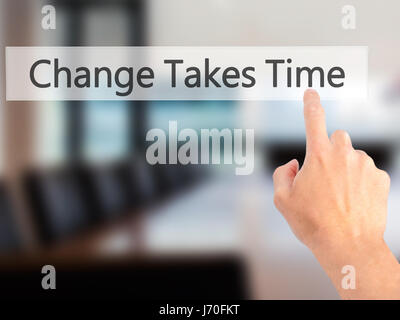 Le changement nécessite du temps - part en appuyant sur un bouton sur l'arrière-plan flou concept . Le commerce, la technologie, internet concept. Stock Photo Banque D'Images