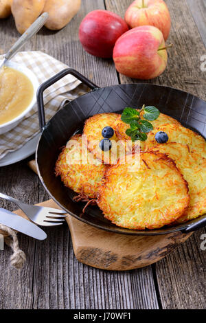 Des frites croustillantes crêpes aux pommes de terre dans une poêle avec de la compote de pomme Banque D'Images