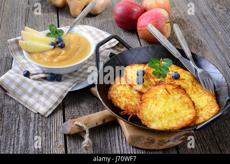 Des frites croustillantes crêpes aux pommes de terre dans une poêle avec de la compote de pomme Banque D'Images