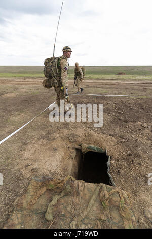 Les soldats britanniques se sont emportés devant un nouveau poste tout en étant défendus par un tanks roumain et un hélicoptère d'attaque lors de l'exercice militaire de l'OTAN « Wind Spring -15 » au stand de tir de Smardan Banque D'Images