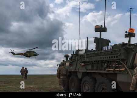 Les soldats courent pour une nouvelle position tout en étant défendus par des chars roumains et un hélicoptère d'attaque lors de l'exercice militaire de l'OTAN « Wind Spring -15 » au champ de tir de Smardan. Banque D'Images
