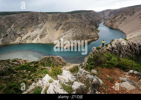 Femme debout sur les falaises au-dessus rivière Zrmanja, Croatie. Banque D'Images