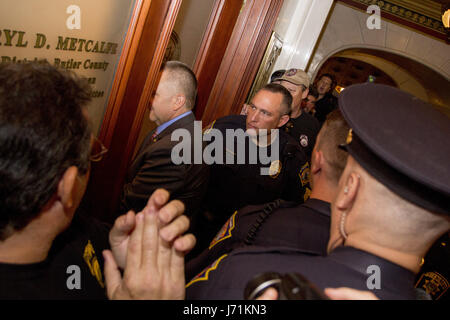 Harrisburg, États-Unis. 22 mai, 2017. Représentant de l'Etat PA Metcalfe entre dans son bureau Daryl entouré par la police et des manifestants avec le groupe Mars sur Harrisburg à la Pennsylvania State Capitol, lundi 22 mai, 2017. Leur objectif est l'adoption de plusieurs textes de loi par l'assemblée législative de l'état, y compris une interdiction sur un nombre illimité de cadeaux aux hommes politiques, réformes de sectorisation, et automatique l'inscription des électeurs. Crédit : Michael Candelori/Alamy Live News Banque D'Images