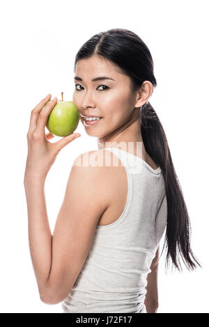 Happy Asian woman holding a green apple Banque D'Images