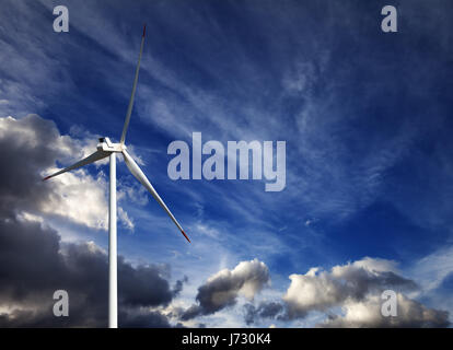 Turbine de vent et ciel bleu avec des nuages de tempête au jour d'été Banque D'Images