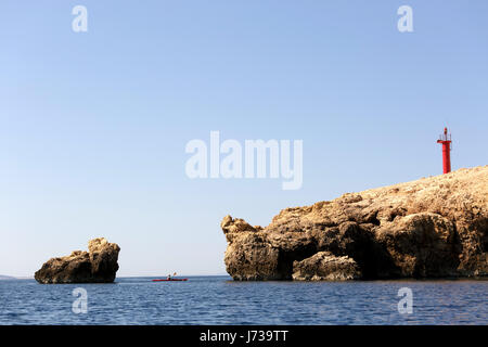 Femme kayak à travers le détroit près de Baska, île de Krk, Croatie. Banque D'Images