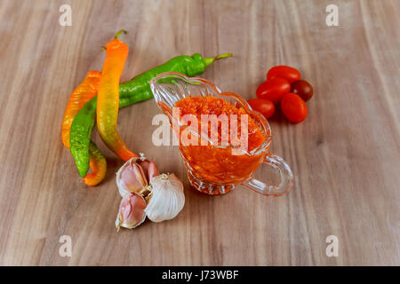 Hot sauce géorgienne adjika brutes et d'ingrédients sur une table en bois adjika Banque D'Images