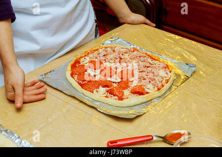 La préparation de la Pizza Margherita. Cuisine ajouter le parmesan râpé. Selective focus Banque D'Images