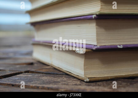 Pile de vieux livres sur fond de bois, gros plan extrême. Profondeur de champ Banque D'Images