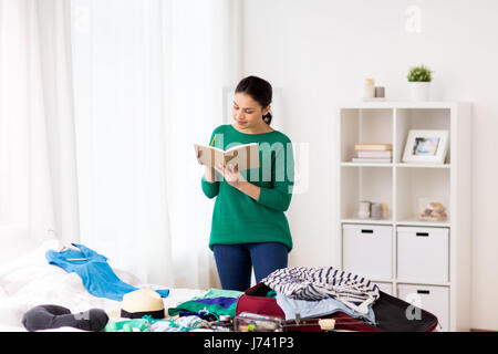 Femme avec la planification de l'ordinateur portable de son voyage à la maison Banque D'Images