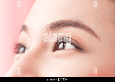 Belle femme asiatique yeux avec de longs cils isolé sur fond rose. Banque D'Images