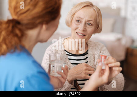 Jolie femme âgée recevant de l'aide médicale Banque D'Images