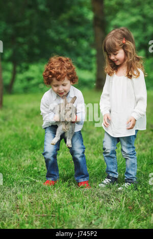 Petit garçon et fille jouant avec lapin Banque D'Images