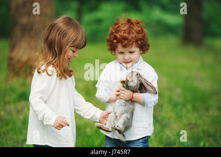 Petit garçon et fille jouant avec lapin Banque D'Images