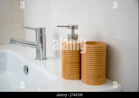 Distributeur de savon et Porte brosse à dents sur un évier de salle de bains Banque D'Images