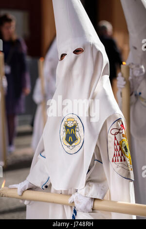 Nazarenos participant à une procession religieuse, avec les robes traditionnelles et capots et portant des bougies pendant la Semana Santa (Pâques) à Séville. Banque D'Images