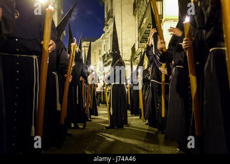 Nazarenos participant à une procession religieuse, avec les robes traditionnelles et capots et portant des bougies pendant la Semana Santa (Pâques) à Séville. Banque D'Images