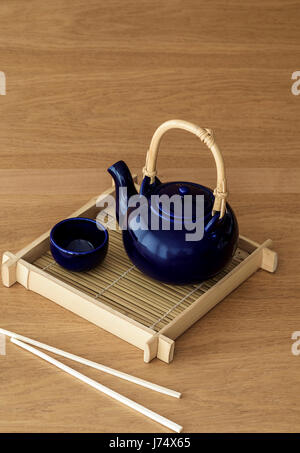 Le thé vert servi en pot poterie bleu sur un plateau de bambou Banque D'Images