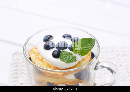 Tasse de yaourt blanc avec des crêpes américaines et bleuets frais - close up Banque D'Images