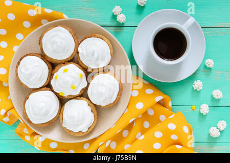 Mini tarte avec une crème d'air sur une assiette et une tasse de café sur un fond de bois. La vue de dessus Banque D'Images